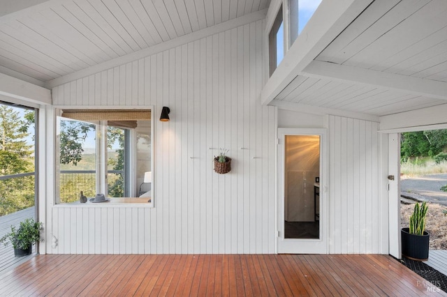 unfurnished sunroom with beam ceiling