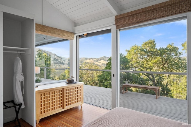 bedroom with vaulted ceiling, wooden ceiling, a mountain view, and multiple windows