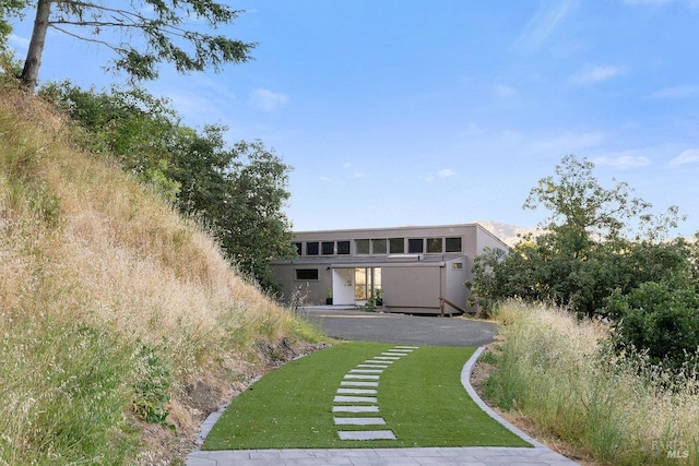 exterior space featuring stucco siding and a front lawn