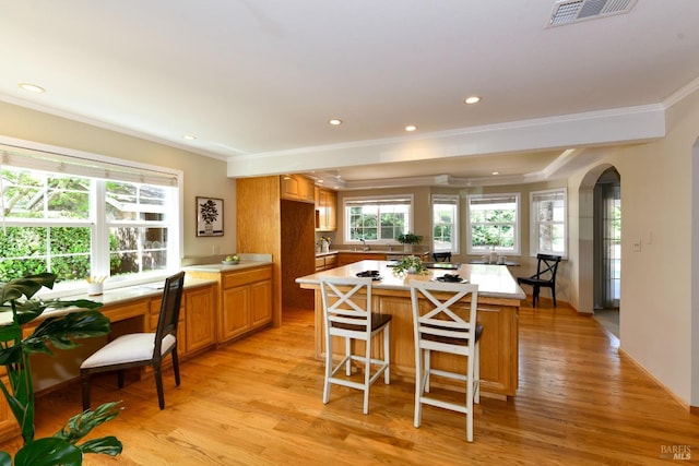 2555 Edgewater Dr, Napa, CA 94558 - kitchen with crown molding, visible vents, arched walkways, light countertops, and a kitchen island