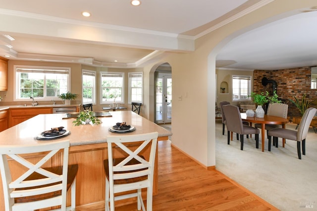 2555 Edgewater Dr, Napa, CA 94558 - kitchen with a sink, a kitchen breakfast bar, crown molding, arched walkways, and light countertops