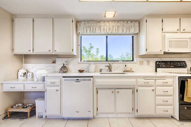 kitchen featuring backsplash, white appliances, light countertops, and a sink