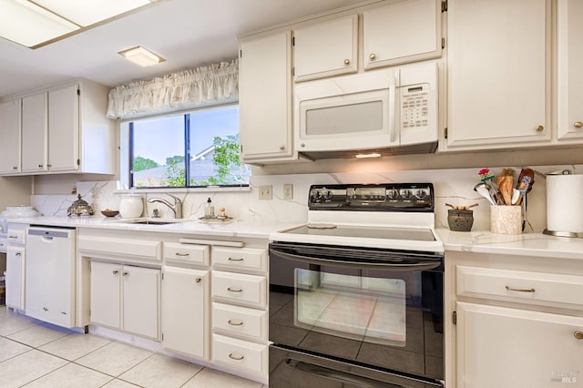kitchen featuring light tile patterned floors, white appliances, a sink, light countertops, and white cabinets