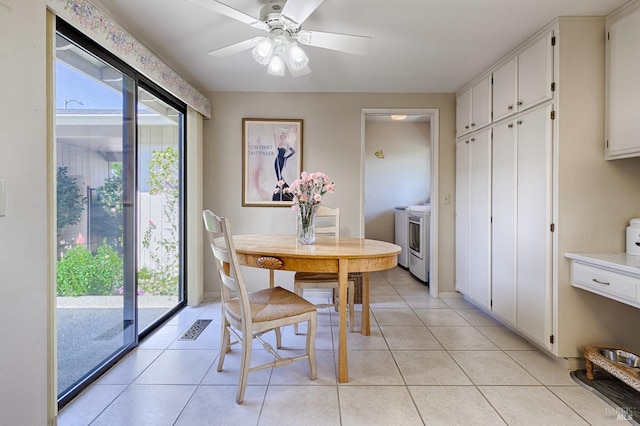 dining space featuring a ceiling fan, washer / clothes dryer, light tile patterned floors, and visible vents