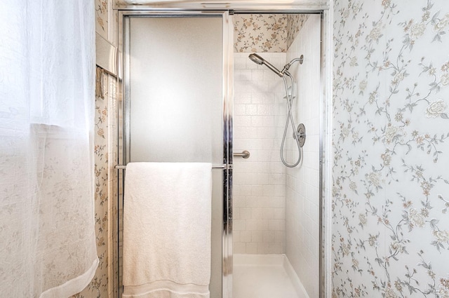 full bathroom featuring a shower stall and wallpapered walls