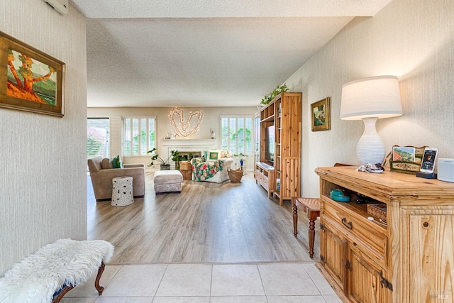 living room featuring a fireplace, light wood-type flooring, and a textured ceiling