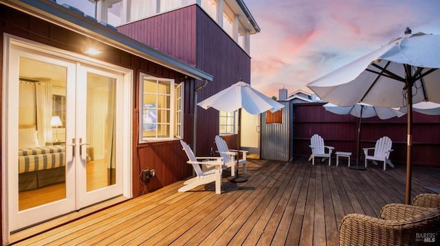 deck at dusk featuring french doors