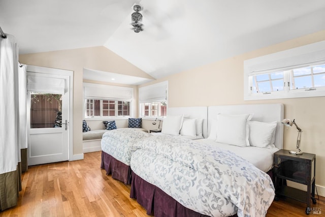 bedroom with light wood-style flooring and vaulted ceiling