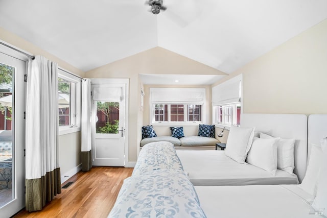 bedroom with lofted ceiling, multiple windows, light wood-style flooring, and access to exterior