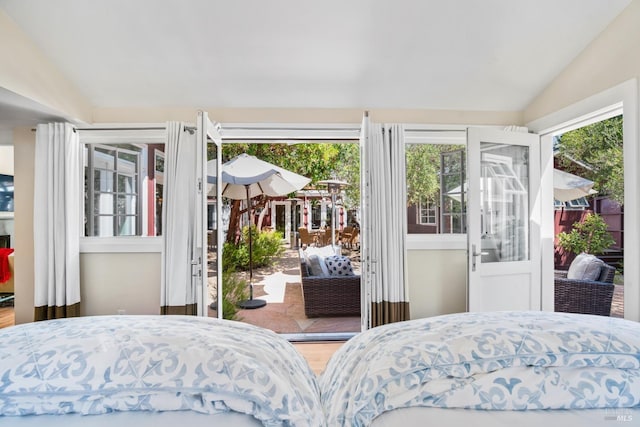 bedroom with vaulted ceiling and access to exterior