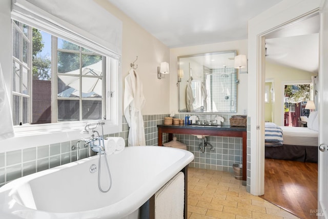 ensuite bathroom with tile walls, ensuite bathroom, and a freestanding tub