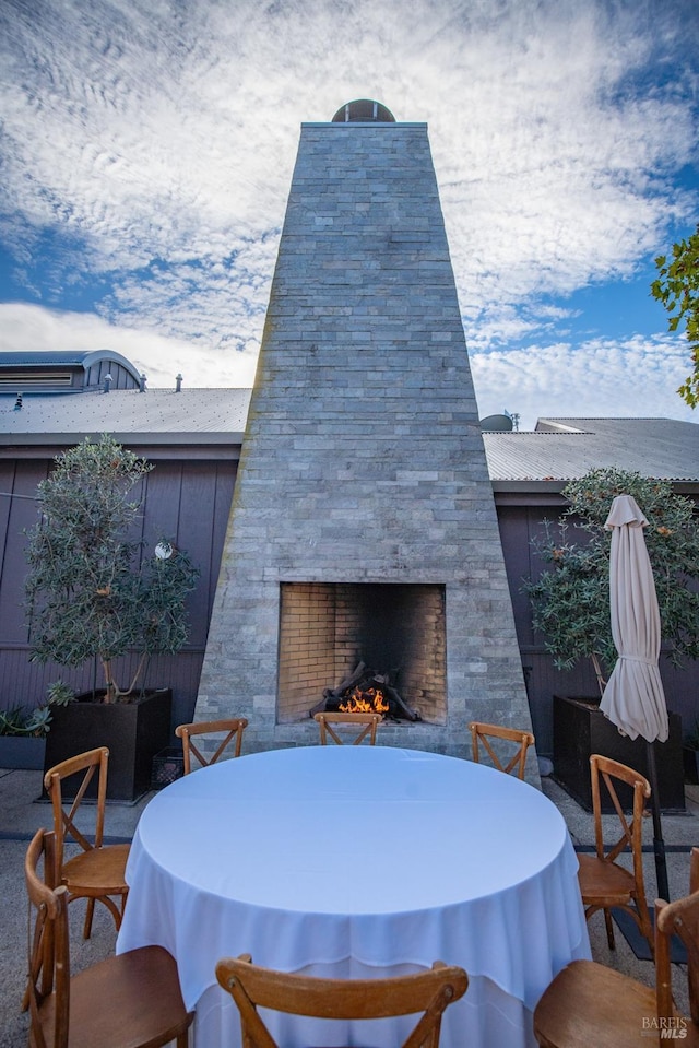 view of patio featuring an outdoor stone fireplace and outdoor dining area
