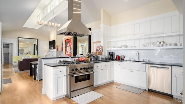 kitchen featuring lofted ceiling, ventilation hood, open floor plan, dark countertops, and appliances with stainless steel finishes