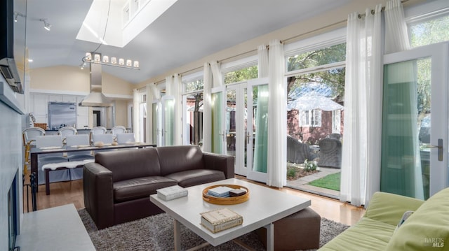 living area featuring vaulted ceiling and wood finished floors