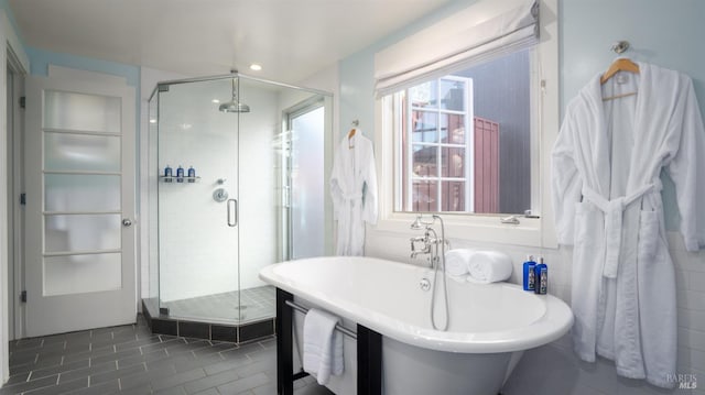 bathroom with a stall shower, tile patterned floors, a freestanding bath, and a sink