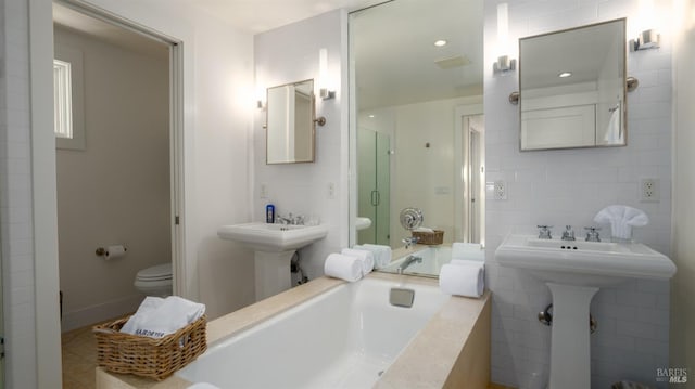 bathroom featuring a shower with shower door, a sink, toilet, tile patterned floors, and a bath