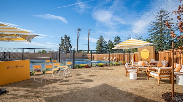 exterior space with fence and a tennis court
