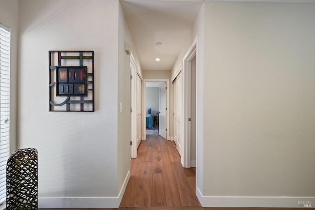hallway with baseboards, recessed lighting, and wood finished floors