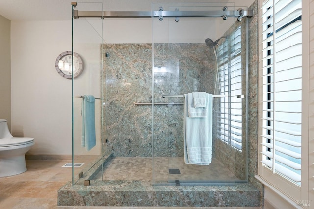 full bathroom with toilet, baseboards, and a stall shower