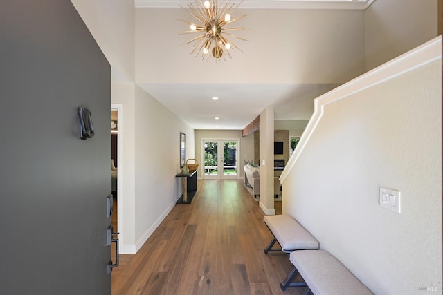 corridor with a chandelier, baseboards, and wood finished floors