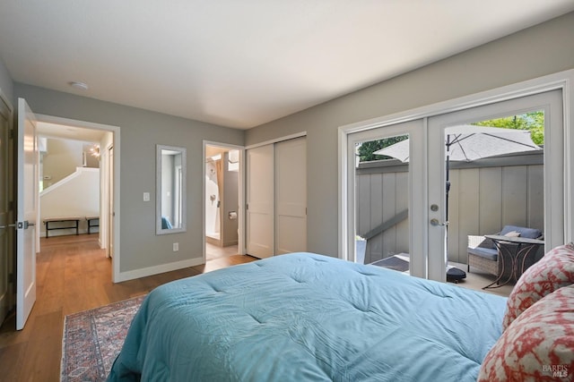 bedroom with baseboards, french doors, wood finished floors, and access to exterior