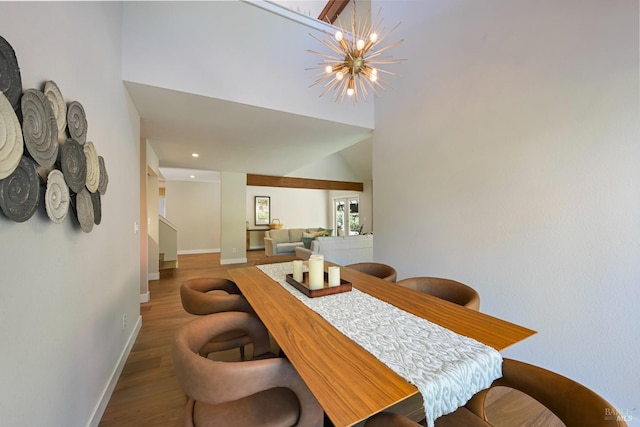 dining room with recessed lighting, baseboards, an inviting chandelier, wood finished floors, and stairway