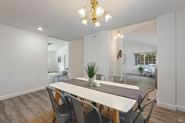dining area with recessed lighting, baseboards, an inviting chandelier, vaulted ceiling, and wood finished floors