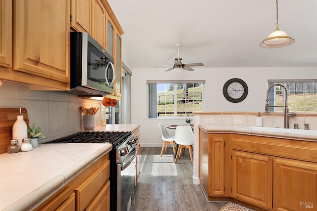 kitchen with stainless steel appliances, tasteful backsplash, a healthy amount of sunlight, and a sink