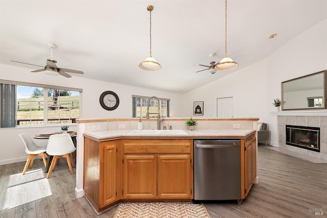 kitchen featuring a sink, stainless steel dishwasher, tile counters, and ceiling fan
