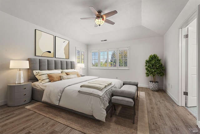 bedroom with baseboards, visible vents, light wood-type flooring, and a ceiling fan