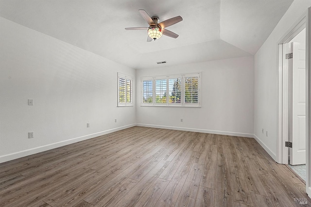 unfurnished room with ceiling fan, baseboards, visible vents, and wood finished floors