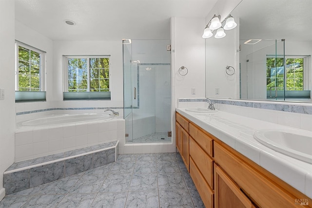 bathroom with a sink, double vanity, a garden tub, and a shower stall