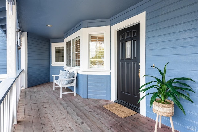 view of exterior entry featuring covered porch