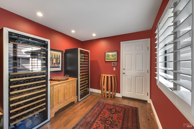 foyer entrance with dark wood-style flooring, recessed lighting, baseboards, and beverage cooler