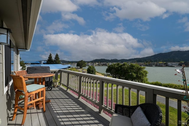 wooden deck with a water and mountain view