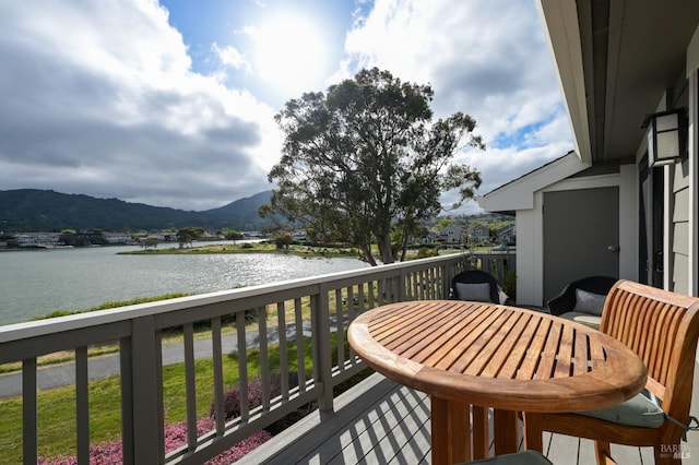 balcony featuring a water and mountain view