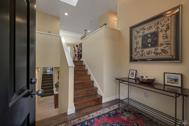 staircase featuring recessed lighting, baseboards, and wood finished floors