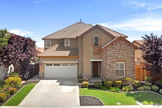 traditional home with driveway, stone siding, stucco siding, and fence