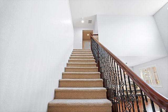 staircase with visible vents and wood finished floors