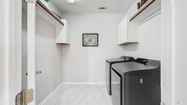 laundry area featuring washing machine and dryer, baseboards, marble finish floor, visible vents, and cabinet space