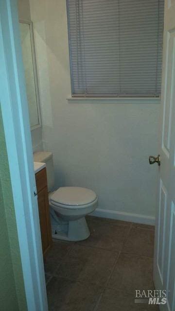 bathroom featuring vanity, toilet, baseboards, and tile patterned floors