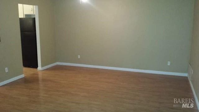 empty room with wood finished floors and baseboards