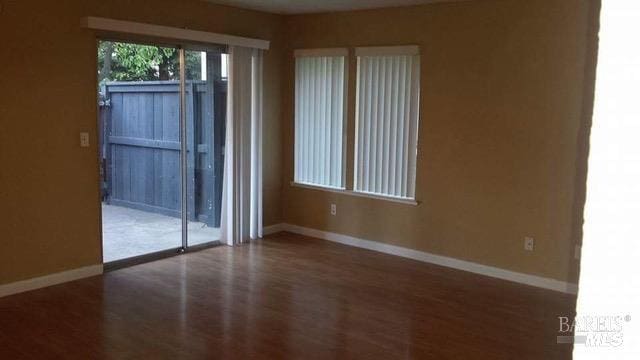 empty room with baseboards and wood finished floors