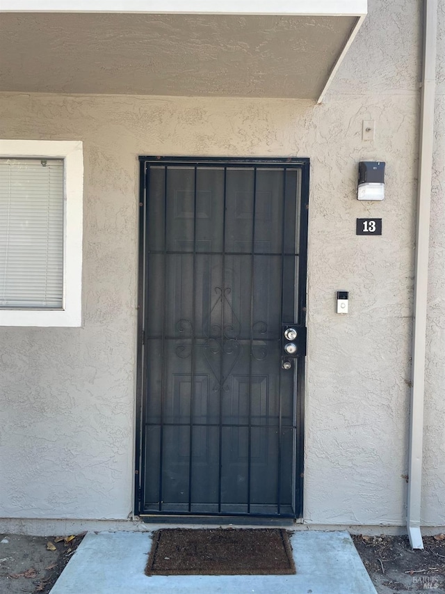 doorway to property featuring stucco siding