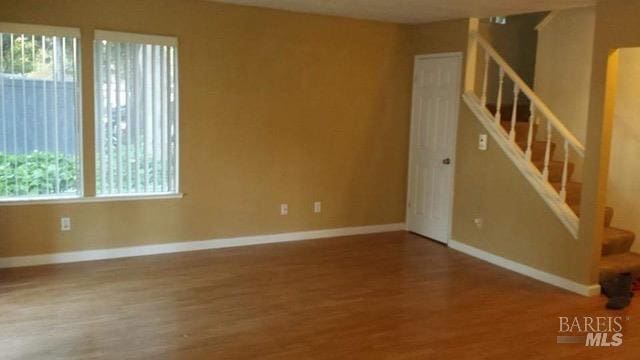 interior space with wood finished floors, baseboards, and stairs