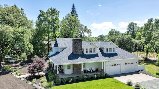 1071 Bale Ln, Calistoga, CA 94515 - view of front facade with a chimney, a garage, a shingled roof, concrete driveway, and a porch