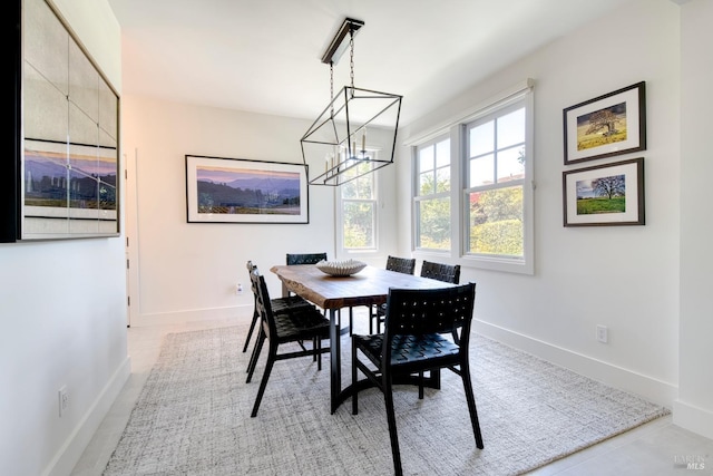 dining area featuring an inviting chandelier and baseboards