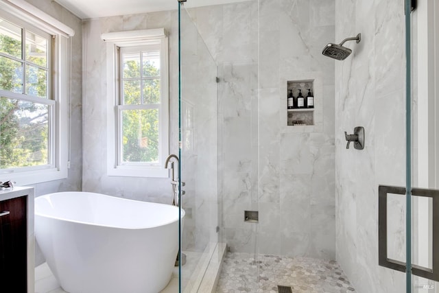 full bath featuring a soaking tub, a shower stall, and a healthy amount of sunlight