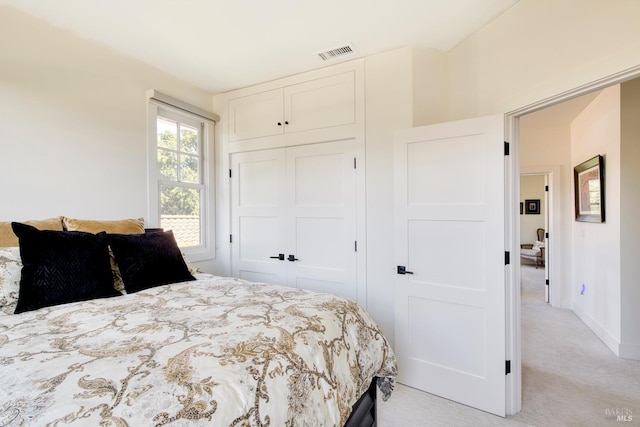 bedroom with light carpet, a closet, baseboards, and visible vents