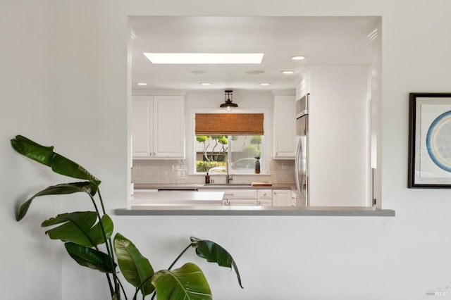 271 Via La Paz Rd, Greenbrae, CA 94904 - kitchen with stainless steel refrigerator, white cabinetry, tasteful backsplash, and a skylight